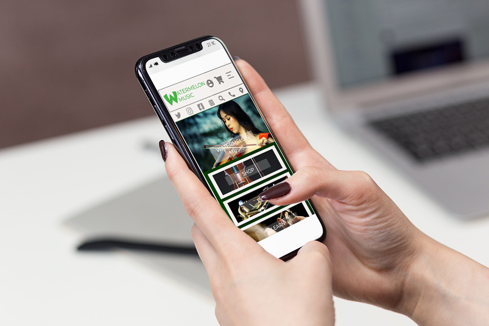 A woman looking at the Watermelon Music mobile website on her cell phone.